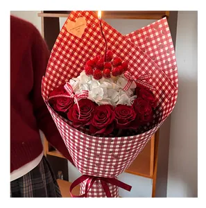 Detailed view of red roses and white hydrangeas in retro checkered wrapping paper.