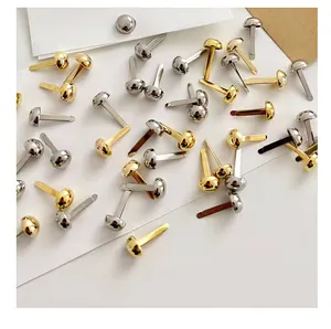 Close-up of assorted gold and silver round head brads for DIY crafts and card making