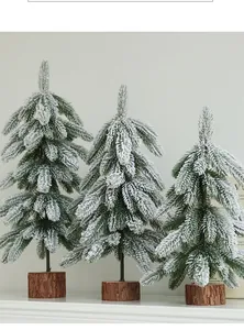 Detailed view of three miniature frosted Christmas trees featuring rustic wooden bases.