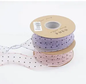 Detail view of light purple and pink polka dot chiffon ribbons on round cardboard spools