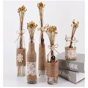 Macro view of rustic glass bottles decorated with natural jute rope and elegant white lace