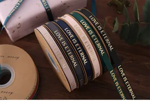 Detail view of 1cm wide ribbed ribbons with gold foil Love is Eternal text for gift wrapping