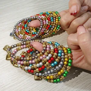 Vista dettagliata di braccialetti elastici colorati in acciaio con ciondoli a cuore