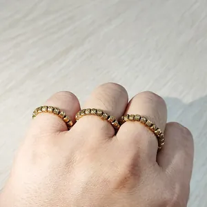 Close-up of golden stainless steel elastic rings with diagonal-striped beads