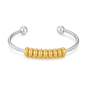 Gros plan d'un bracelet jonc élastique en acier inoxydable avec dix perles dorées