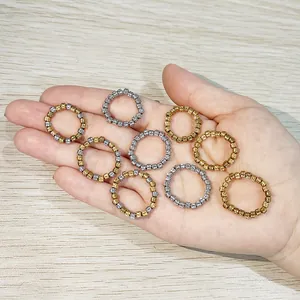 Close-up of several stainless steel stretch rings with textured beads held in hand