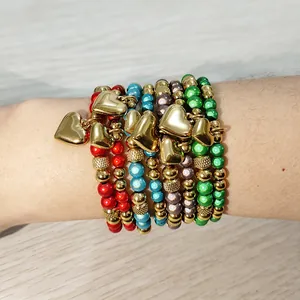 Vista dettagliata di braccialetti elastici con perline colorate e ciondoli a cuore dorati