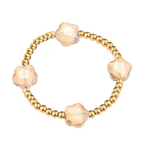 Nahaufnahme von champagnerfarbenen Blumenkristallen an einem goldenen Edelstahlarmband