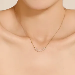 Nahaufnahme einer zierlichen 18K vergoldeten Kette mit sieben funkelnden Zirkonia-Perlen