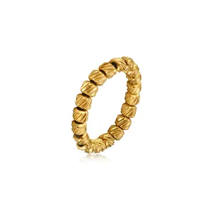 Close-up of gold-plated stainless steel elastic ring with textured beads detail.