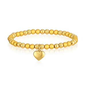 Dettaglio di bracciale con perline in acciaio inossidabile e ciondolo a cuore