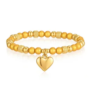 Dettagliata vista ravvicinata di un bracciale elastico in oro con ciondolo a forma di cuore