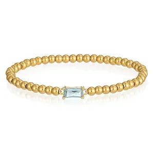 Nahaufnahme eines vergoldeten Edelstahl-Perlenarmbands mit hellblauem Schmuckstein.