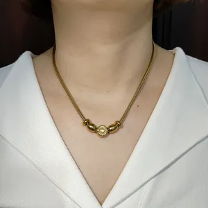 Goldene Schlangenkette Halskette mit Blumenperle Mittelstück für elegante Damenmode.