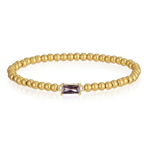 Nahaufnahme eines vergoldeten Perlenarmbands aus Edelstahl mit einem violetten Zirkon