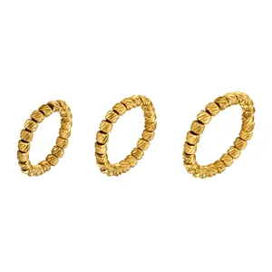 Detailed macro view of three golden stainless steel stretch rings with textured beads design