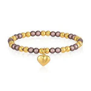 Dettaglio di un bracciale elastico in acciaio inossidabile con ciondolo a cuore oro