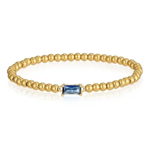 Nahaufnahme des goldfarbenen Perlenarmbands mit rechteckigem blauem Zirkonia-Stein