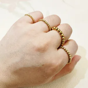 Vista detallada de varios anillos elásticos de cuentas de acero de titanio chapado en oro