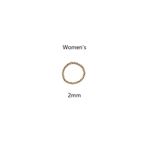 Detalle de un anillo elástico de cuentas de acero de titanio dorado de 2mm para mujer
