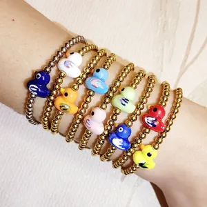 Close-up of stackable colorful ceramic duck beaded bracelets with gold steel beads