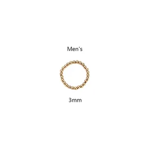 Detalle de un anillo elástico de cuentas doradas de 3mm para hombre en acero de titanio