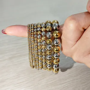 Close-up of gold and silver stainless steel beaded elastic bracelets in various sizes