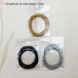 Close-up of 1.7mm stainless steel spring bracelets in gold, black, and silver bags