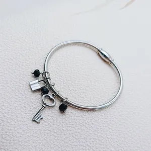 Detailed view of stainless steel vintage bracelet with heart-key charms and magnetic clasp.