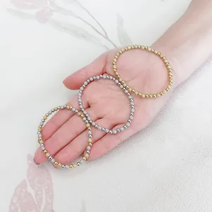 Nahaufnahme von drei funkelnden Edelstahl-Perlenarmbändern mit Sand-Finish auf der Hand