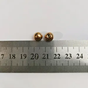 Detail macro shot of golden stainless steel ball heads with screw threads on a ruler