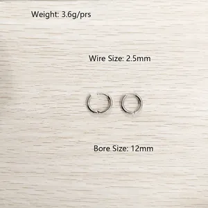 Vue rapprochée de boucles d'oreilles créoles en acier argenté avec mesures de taille