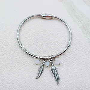 Close-up of stainless steel spring bracelet with feather charms and magnetic clasp