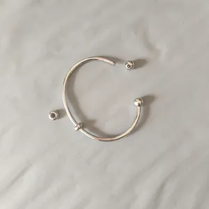 Detailed macro view of a silver stainless steel screw-off ball end cuff bracelet