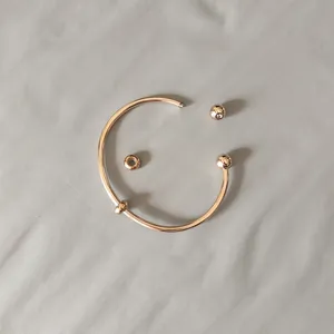 Detail of rose gold stainless steel DIY open bangle with screw-off ball end and beads
