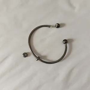 Detailed macro shot of gunmetal titanium steel open bangle with a screw-off ball end
