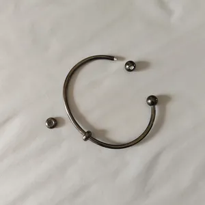 Close-up detail showing the screw-off ball end on a gunmetal stainless steel cuff bracelet