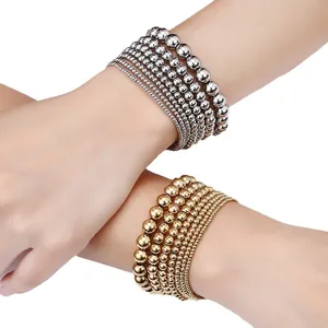Vista dettagliata di bracciali elastici con perline in acciaio inossidabile argento e oro