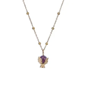 Dettaglio di una collana dorata in acciaio inossidabile con pendente in pietra naturale viola