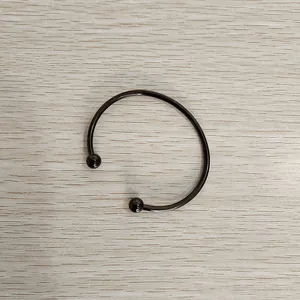 Detailed view of a sleek black stainless steel open cuff bracelet with ball ends