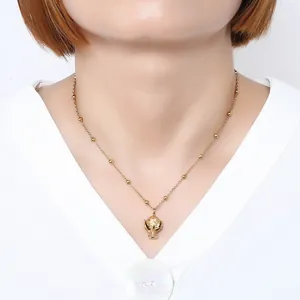 Primo piano dettagliato che mostra una collana con pendente trofeo foglia oro su un modello