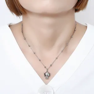 Primo piano di collana in acciaio inox con ciondolo a trofeo indossata da modella