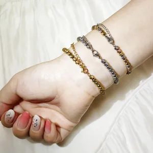 Nahaufnahme von drei strukturierten Edelstahl-Perlenarmbändern am Handgelenk einer Frau