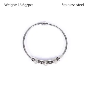 Primer plano de una pulsera de acero inoxidable con cristales y cuentas con relieve.
