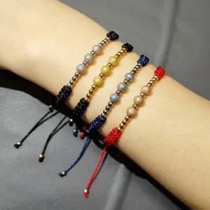 Primo piano di braccialetti intrecciati con perle in acciaio inossidabile sabbiato oro