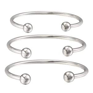 Detailed view of three stainless steel cuff bracelets with screw-off ball ends.
