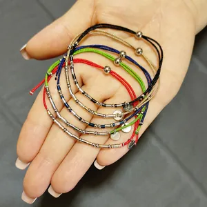 Vue détaillée de bracelets en cordon réglables colorés avec perles en acier sur main