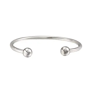 Detailed macro view of a minimalist stainless steel open bangle with screw-on ball ends