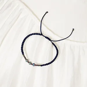 Vista dettagliata del bracciale in corda intrecciata blu scuro con perle in acciaio inox