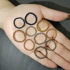 Vista detallada de varios anillos elásticos de cuentas de acero inoxidable en una palma.